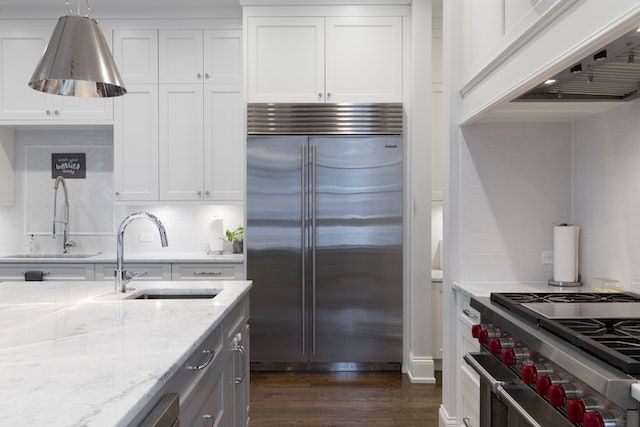 A-modern-kitchen-in-a-rental-with-stainless-steel-appliances-white-marble-countertops-white-cabinets-and-a-large-center-island A-modern-kitchen-in-a-rental-with-stainless-steel-appliances-white-marble-countertops-white-cabinets-and-a-large-center-island